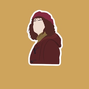 Peut inclure: Une femme aux cheveux bruns bouclés portant un manteau bordeaux à capuche, un béret bordeaux et un pull col roulé beige.