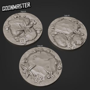 May include: Three gray, circular bases with textured surfaces, each featuring a rock, starfish, and clover-like shapes. The text "GOONMASTER" is at the top left. Each base is labeled with a style number.