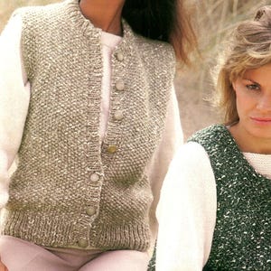 May include: Two women wearing knitted vests. One vest is a light green colour with a button-up front. The other vest is a darker green colour with a scoop neck. Both vests are worn over white long-sleeved shirts. The vests have a textured, speckled appearance.