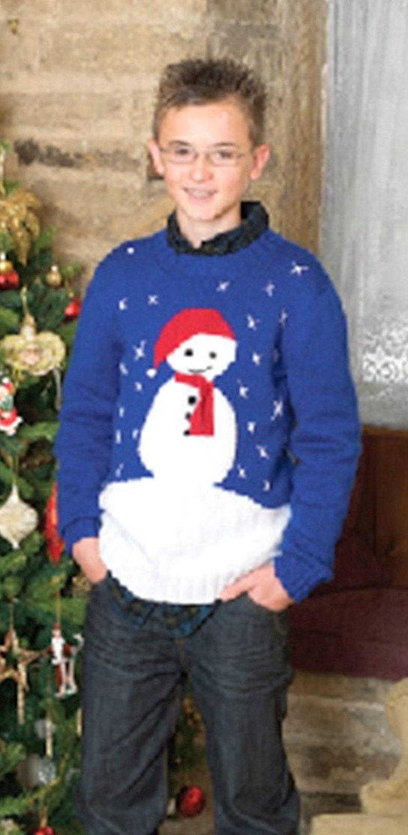 May include: A blue knitted sweater with a white snowman design. The snowman has a red hat and a red scarf. The sweater has a snowflake pattern.