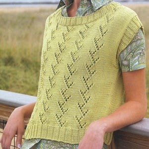 May include: A light green sleeveless knitted vest with a lacy pattern. The vest has a round neckline and a slightly cropped length.