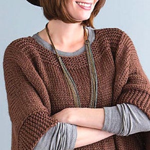 May include: A brown knitted sweater with a loose, oversized fit. The sweater has a wide neckline and long sleeves.