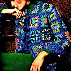 May include: A blue crocheted jacket with a colorful granny square pattern. The jacket has a tie closure at the front and long sleeves.