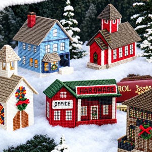 May include: A collection of miniature plastic canvas buildings including a blue house, a red schoolhouse, a white church, and a red hardware store with the text OFFICE and HARDWARE, all decorated with wreaths and set against a snowy backdrop.