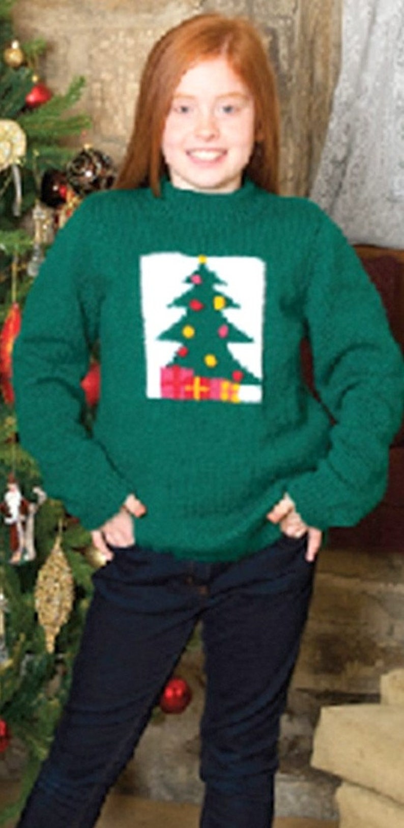 May include: A green knitted sweater with a white appliqu&eacute; of a Christmas tree with red and yellow ornaments. The sweater is worn by a person with red hair.