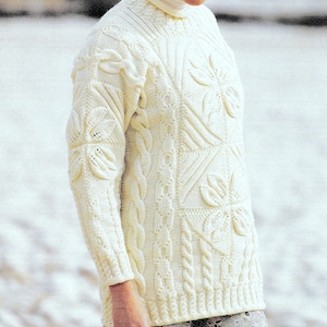 Peut inclure: Pull à manches longues de couleur crème avec un col roulé. Le pull présente des motifs complexes de tricot torsadé et de fleurs. Le design comprend des motifs de feuilles et de carrés en relief, créant un aspect texturé. Le pull est fait d'une matière épaisse et chaude.