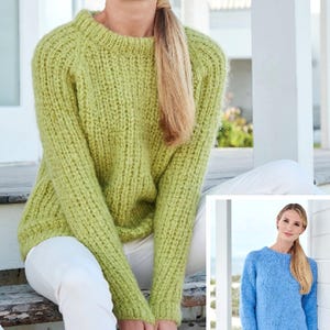 Può includere: Un maglione lavorato a maglia verde chiaro con scollo tondo e maniche lunghe. Il maglione ha una trama a coste ed è abbinato a pantaloni bianchi. L'immagine include anche un'immagine più piccola di un maglione blu.