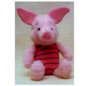May include: A plush toy of a small pink pig character with large pointed ears, a round snout, and dark eyes. The figure is wearing a knitted jumper featuring horizontal stripes in alternating shades of dark pink and light red across the torso.