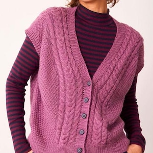 Puede incluir: Un chaleco de punto de cable de color malva sin mangas con cierre de botones.