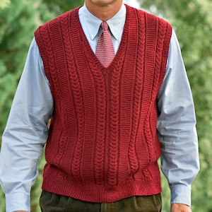 May include: A burgundy cable-knit sweater vest with a V-neck. The vest is worn over a light blue dress shirt and a patterned tie. The overall style is classic and preppy, suitable for layering or as a standalone garment.