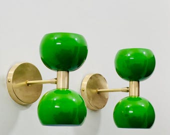 May include: A pair of brass wall sconces with green glass shades. Each sconce has two shades, one on top of the other.