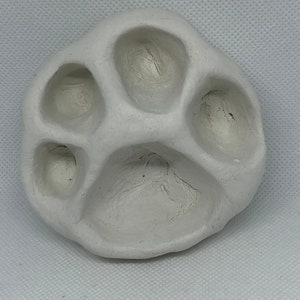 May include: White ceramic paw print mould with five indentations for making paw print crafts.