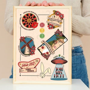 Puede incluir: Una impresión enmarcada con un fondo rosa claro que presenta nueve ilustraciones coloridas. Las ilustraciones incluyen una ruleta, un reloj, un molino de viento, un teléfono, un OVNI, un conejo y un letrero que dice "blink-182". La impresión también incluye el texto "Tread the thought of our very", "Don't waste your time on me", "Keep your feel still", "We're telling a lie", "Aliens Exist", y "Tom was right".