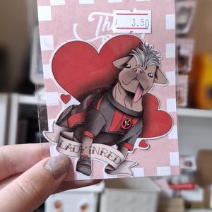 Peut inclure: Un autocollant représentant un carlin de dessin animé portant un costume de super-héros rouge et noir avec un cœur et le texte "Lady In Red".