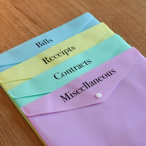 May include: Four pastel coloured plastic folders with labels for Bills, Receipts, Contracts, and Miscellaneous.