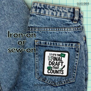 May include: Close-up of blue denim jeans with a square patch on the back pocket. The patch reads "IT'S THE FINAL DRAFT THAT COUNTS" in black and green text. The text "Iron-on or sew-on" is above the jeans.