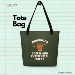 Puede incluir: Un bolso tote de color verde oscuro con asas negras. La bolsa presenta el texto "Tote Bag" en la parte superior y la frase "RUNNING ON COFFEE AND EXISTENTIAL DREAD" con un gráfico de taza de café en el centro. La marca es visible.