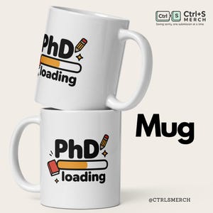May include: Two white ceramic mugs stacked. Each mug has the text "PhD loading" with a pencil and book graphic. The word "Mug" is printed in large black letters. The Ctrl+S Merch logo is in the top right corner.