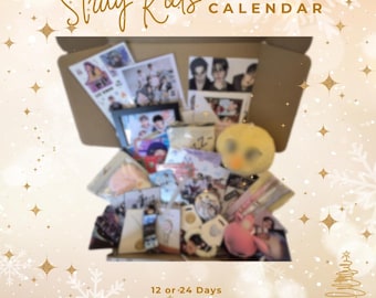 May include: An open cardboard box filled with Stray Kids merchandise, including photos, plush toys, and jewelry. The box is labeled "Stray Kids ADVENT CALENDAR" and includes text indicating it contains gifts, stickers, and more for 12 or 24 days.