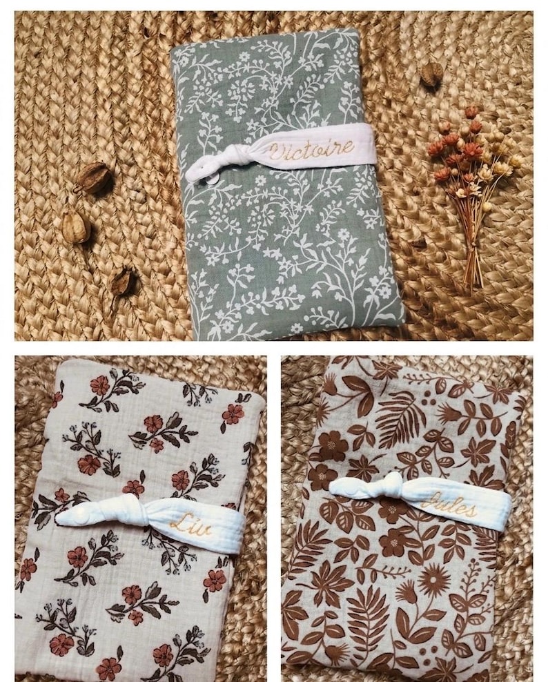 Puede incluir: Tres mantas para beb&eacute; con estampados florales en verde salvia, beige y marr&oacute;n, cada una asegurada con una banda el&aacute;stica blanca. Las bandas est&aacute;n bordadas con nombres. Las mantas se exhiben sobre una superficie de yute tejido.