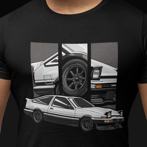 May include: A black t-shirt with a white graphic of a Toyota AE86 car. The car is shown in three different angles, with the front, side, and rear views.