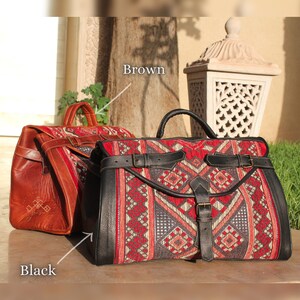 May include: Two leather travel bags with a red, black and white geometric pattern. One bag is brown leather and the other is black leather. The bags have a buckle closure and a top handle.