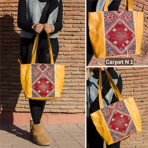May include: A yellow leather tote bag with a colorful embroidered design. The design features a geometric pattern with red, pink, and gray accents. The bag has a zipper closure and two top handles.