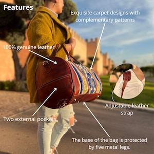 Puede incluir: Una bolsa de viaje de cuero marr&oacute;n con un dise&ntilde;o de tapiz tejido colorido. La bolsa tiene dos bolsillos externos, una correa de cuero ajustable y cinco patas de metal en la parte inferior.