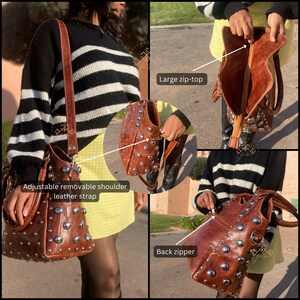 May include: A brown leather tote bag with silver studs. The bag has a large zip-top closure, an adjustable removable shoulder strap, and a back zipper.