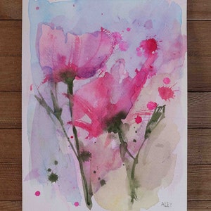 May include: Watercolor painting of pink flowers with a light blue background. The flowers are painted in a loose, abstract style with splashes of pink and green paint. The artist's signature, "ALEY", is in the bottom right corner.