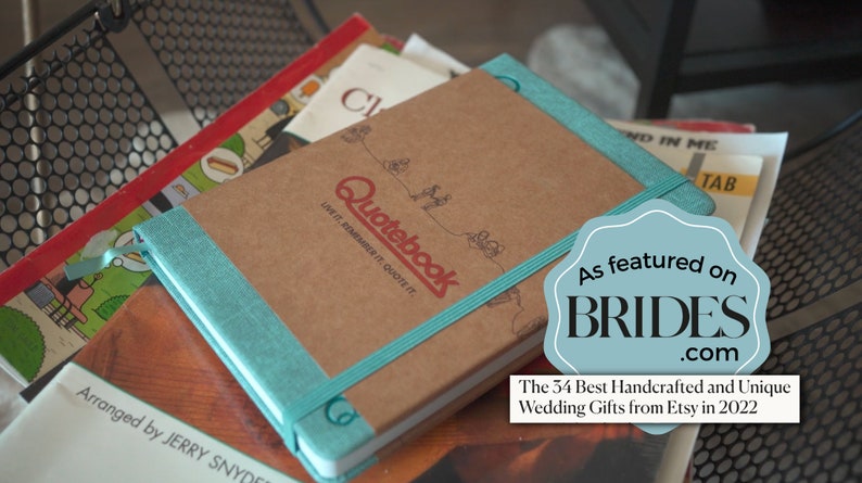 May include: A brown leather bound journal with a teal ribbon bookmark. The journal has the words 'Quotebook' and 'Live it. Remember it. Quote it.' printed on the front cover. The journal has a sticker that says 'As featured on BRIDES.com' and 'The 34 Best Handcrafted and Unique Wedding Gifts from Etsy in 2022'.