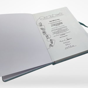 Puede incluir: Un cuaderno azul abierto con las palabras "Our Gift to You" y "I'm part everything, so I can do anything." escritas en la cubierta interior. El cuaderno tiene una ilustraci&oacute;n en blanco y negro de una persona subiendo una escalera.