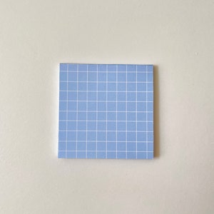 May include: A light blue sticky note with a white grid pattern.