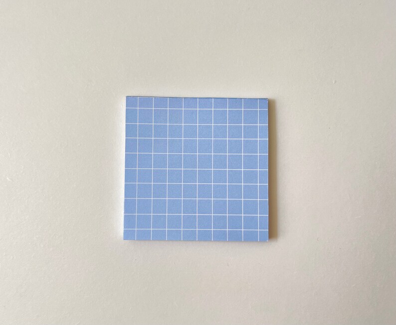May include: A light blue sticky note with a white grid pattern.