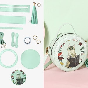 May include: A DIY kit for making a light green round purse with a cat illustration and the text 'Love makes your life getting better'. The kit includes two round pieces of leather, a strap, a tassel, two metal rings, two pieces of leather for the strap, and a roll of tape.