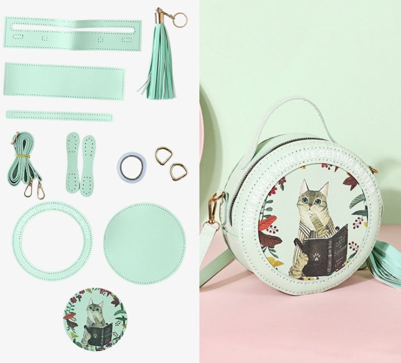 May include: A DIY kit for making a light green round purse with a cat illustration and the text 'Love makes your life getting better'. The kit includes two round pieces of leather, a strap, a tassel, two metal rings, two pieces of leather for the strap, and a roll of tape.