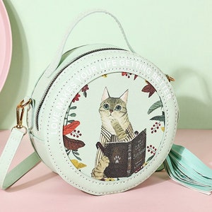 May include: A light green round purse with a cat illustration and the text 'Love makes your life getting better'.