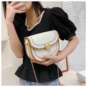 May include: White faux leather shoulder bag with a brown stitched trim and a gold Mickey Mouse shaped clasp. The bag has a gold chain strap.