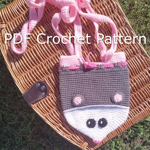May include: A pink and gray crocheted bag with a white face and black eyes. The bag has a pink strap and the text "PDF Crochet Pattern" is visible in the image.
