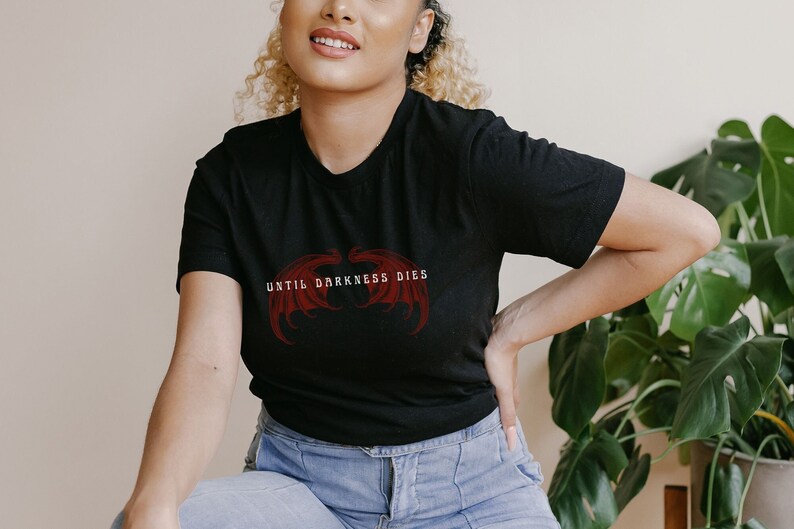 May include: A black t-shirt with a red graphic of wings and the text "UNTIL DARKNESS DIES".