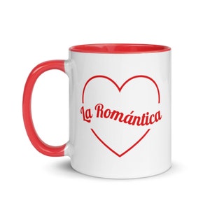 Könnte beinhalten: Weiße Keramiktasse mit rotem Rand und Henkel. Die Tasse zeigt ein rotes Herz mit dem Text "La Romántica" darin.