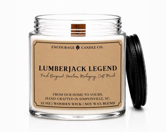 May include: A clear glass candle jar with a wooden wick and a black lid. The tan label reads: ENCOURAGE CANDLE CO. LUMBERJACK LEGEND, Fresh Bergamot, Heirloom Mahogany, Soft Musk, FROM OUR HOME TO YOURS. HAND-CRAFTED IN SIMPONVILLE, SC. 12 OZ | WOODEN WICK | SOY WAX BLEND.