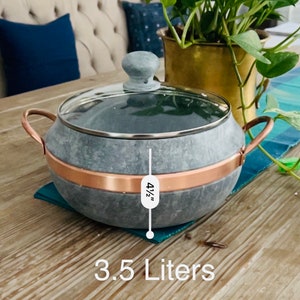 K&ouml;nnte beinhalten: Ein grauer Specksteintopf mit Kupferrand und Glasdeckel. Der Topf ist 11,4 cm hoch und fasst 3,5 Liter.