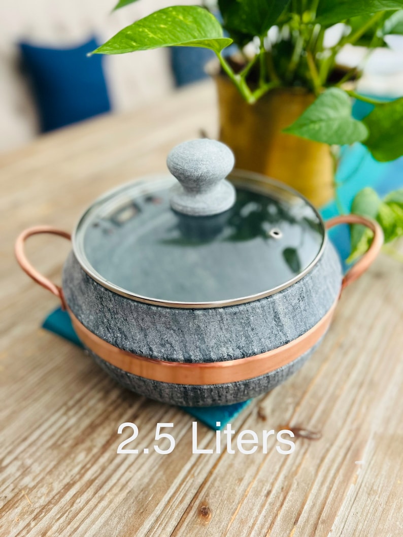 K&ouml;nnte beinhalten: Ein grauer Steintopf mit Kupferrand und einem grauen Steindeckel. Der Topf hat ein Fassungsverm&ouml;gen von 2,5 Litern.