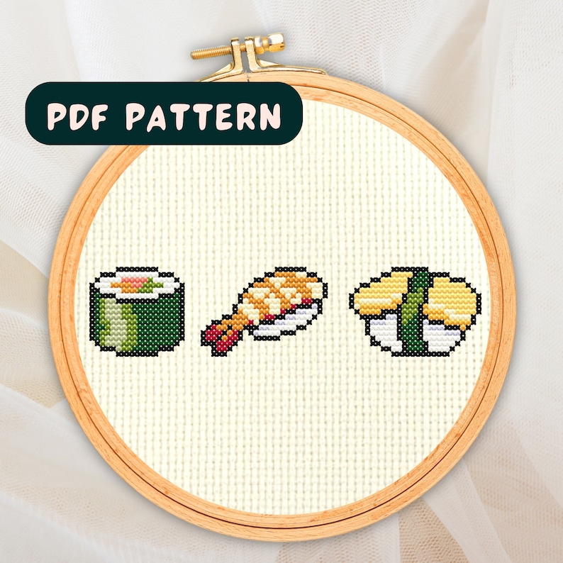 May include: A cross stitch pattern featuring three different types of sushi: a green maki roll, a nigiri with a shrimp topping, and a yellow tamago nigiri.