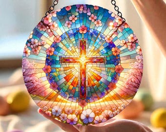 May include: A round stained glass panel featuring a cross at the center, surrounded by colorful floral and geometric patterns. The panel is held by a black chain and displays a vibrant array of colors including blue, orange, and pink.