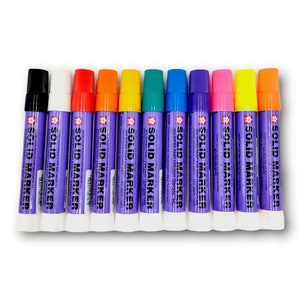 May include: A collection of eleven solid paint markers in various colors, including black, white, red, orange, yellow, green, blue, purple, and pink. Each marker has a purple label with white text that reads "SOLID MARKER".