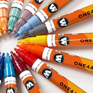 May include: A variety of acrylic paint markers arranged in a circle. The markers are orange and black with the text "ONE4ALL™ ACRYLIC 127H5" printed on them. The tips of the markers are facing inward, revealing a rainbow of colors.