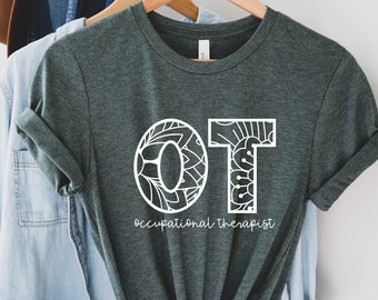 May include: A dark green t-shirt with a white design of the letters "OT" with a mandala pattern inside the letters. The text "occupational therapist" is written below the letters.