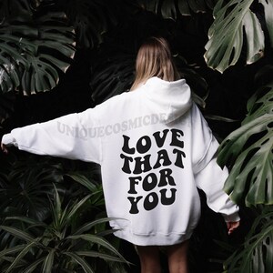 May include: White hooded sweatshirt with the text "LOVE THAT FOR YOU" printed in black on the back.